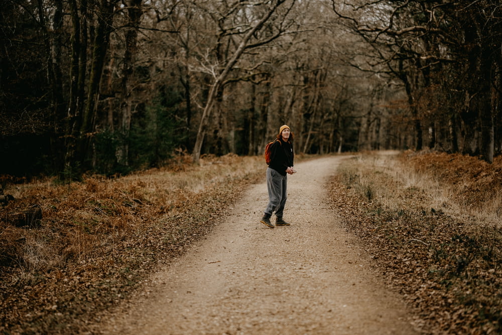 Un uomo che cammina lungo una strada sterrata nel bosco