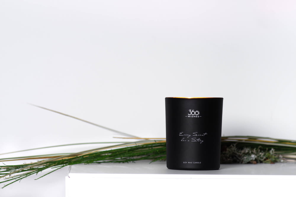 a black candle sitting on top of a white shelf