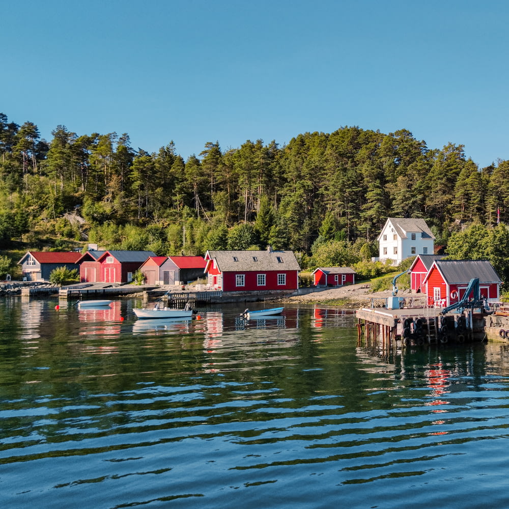 a row of red houses sitting on top of a body of water