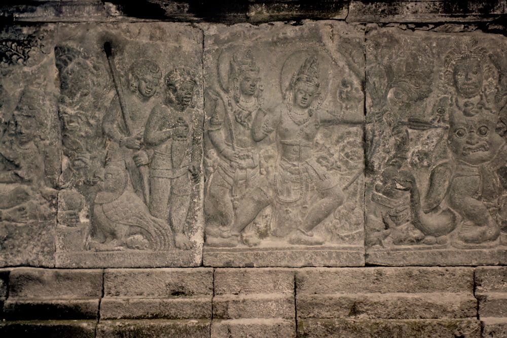 a stone wall with carvings of people and animals on it