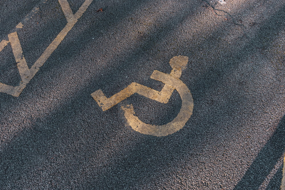 a handicapped sign painted on the asphalt of a street