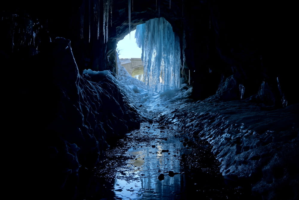 um túnel escuro com gelo pendurado em seus lados