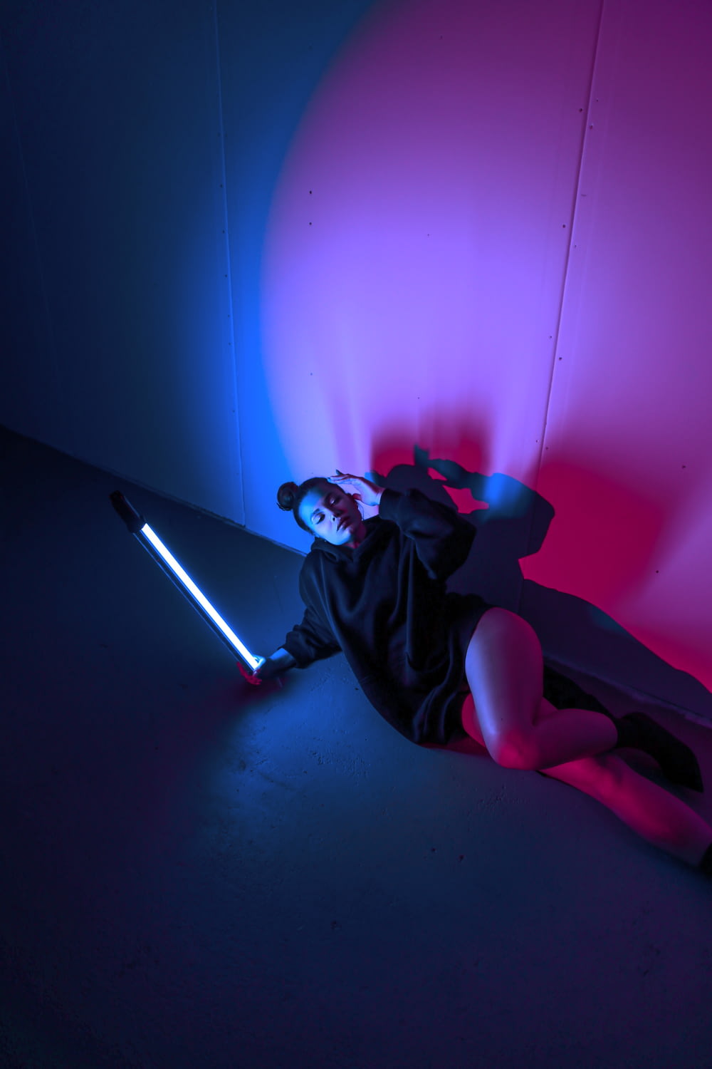 a person laying on the ground with a light saber