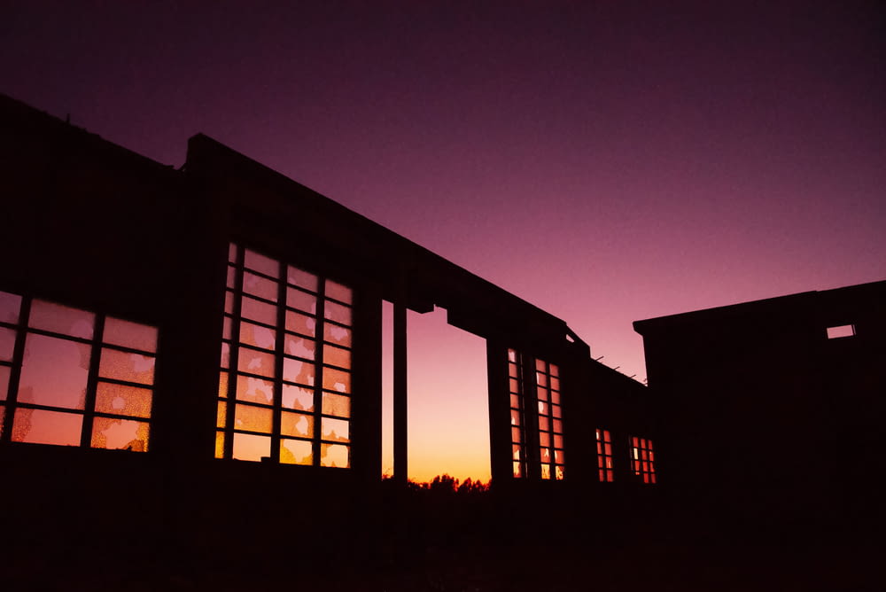 a silhouette of a building with windows at sunset