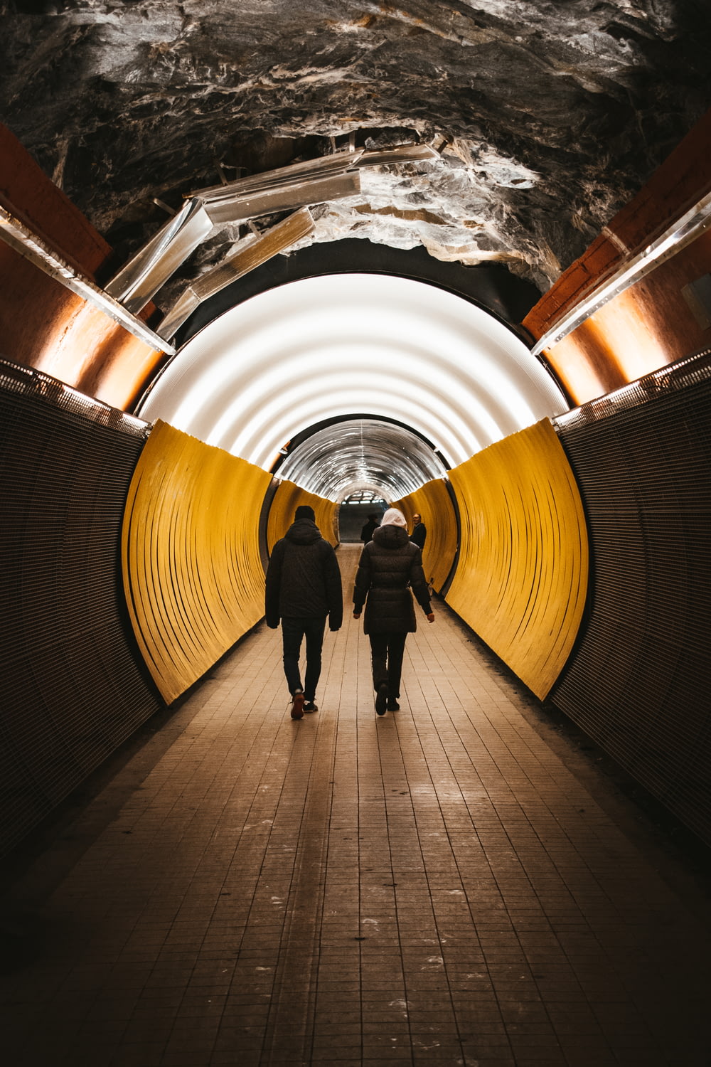 Un par de personas que están caminando en un túnel