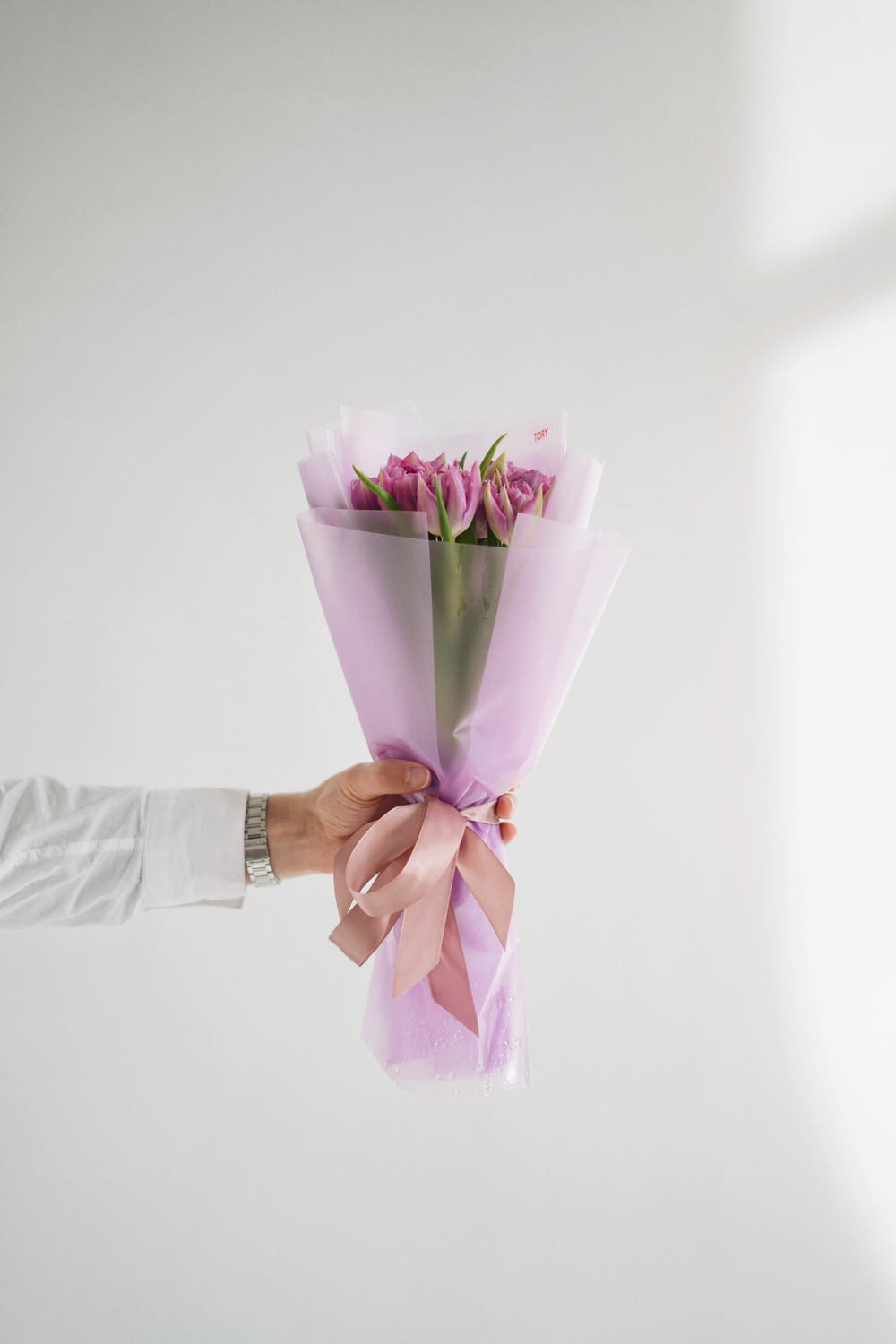 a person holding a bouquet of pink roses