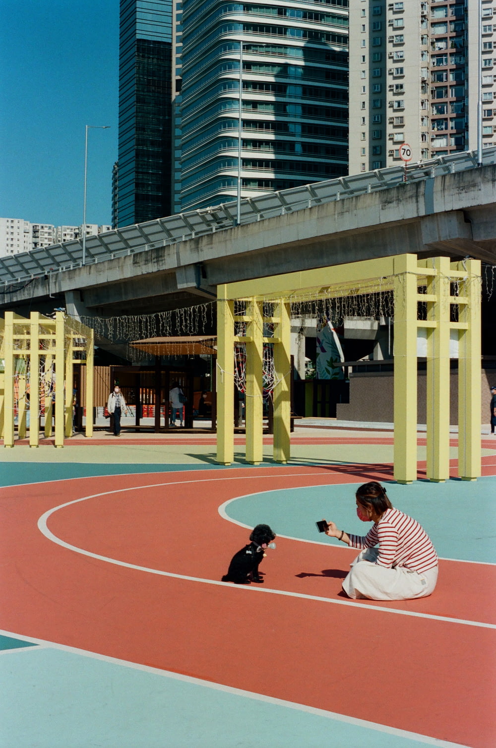 a woman kneeling down next to a dog on a basketball court