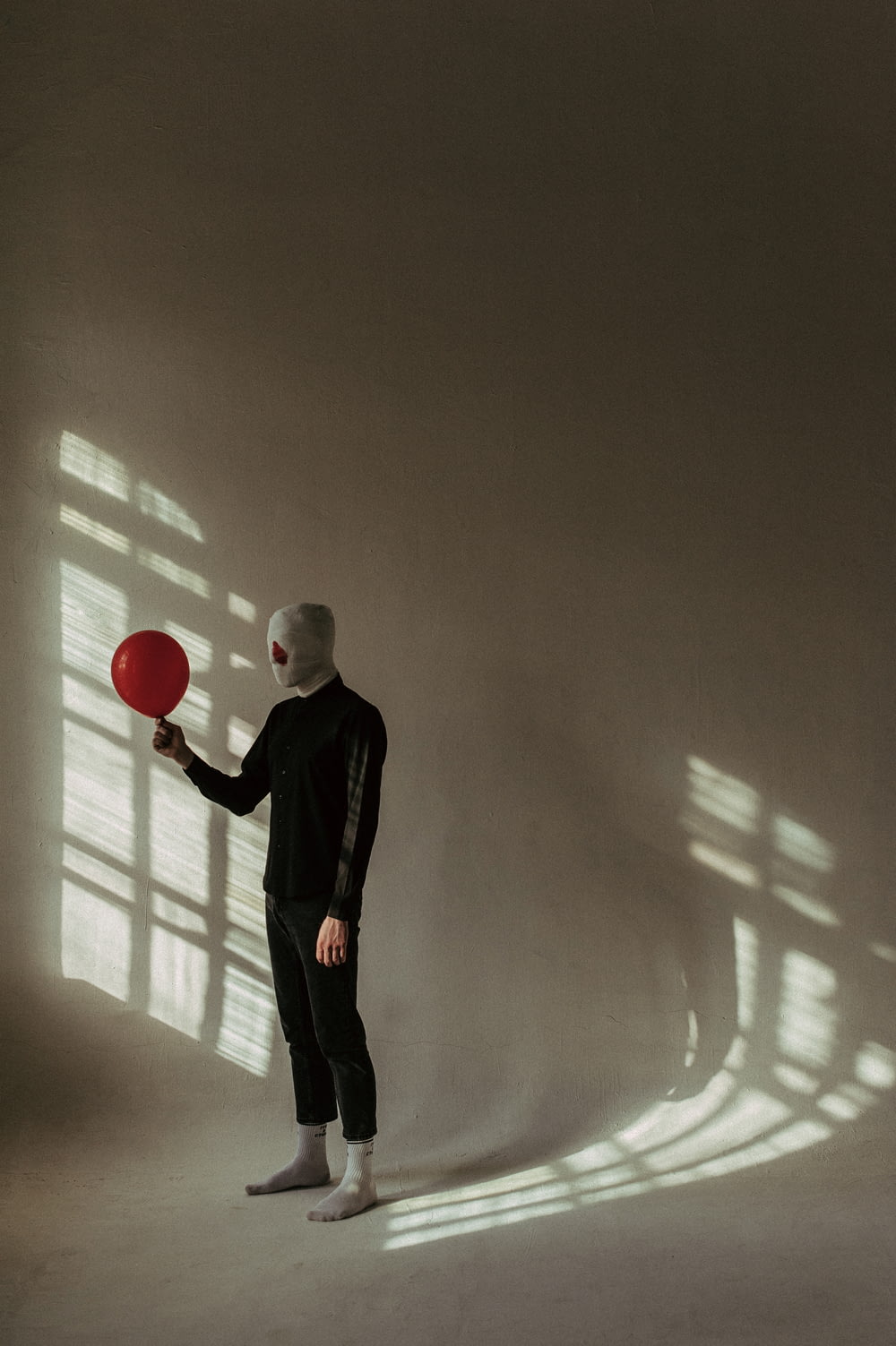 a man in a white mask holding a red frisbee