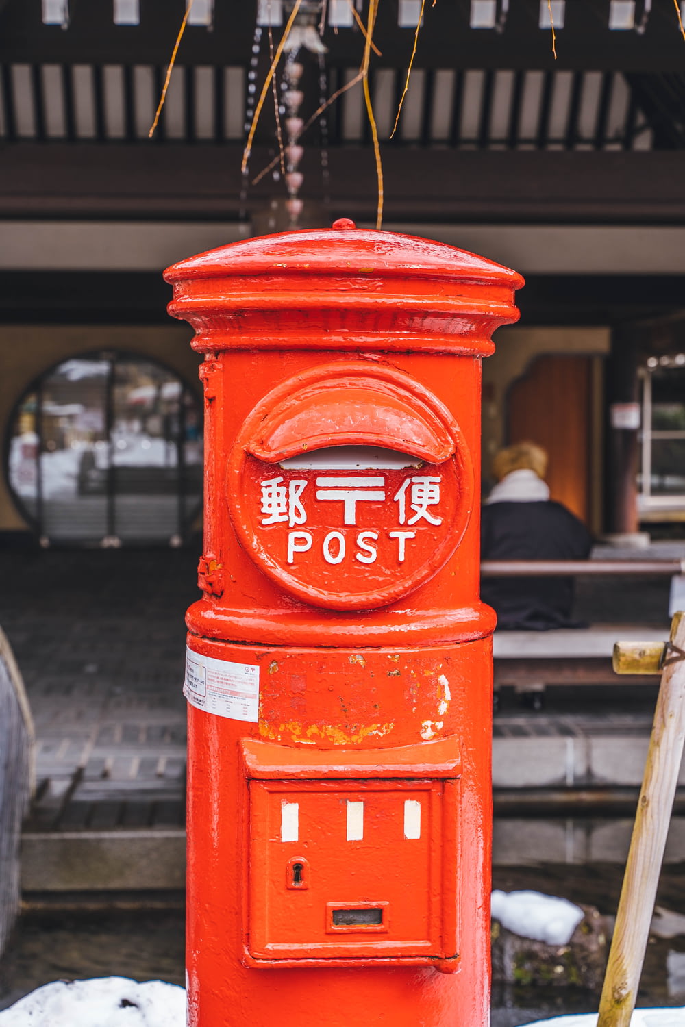 a red post box sitting in front of a building