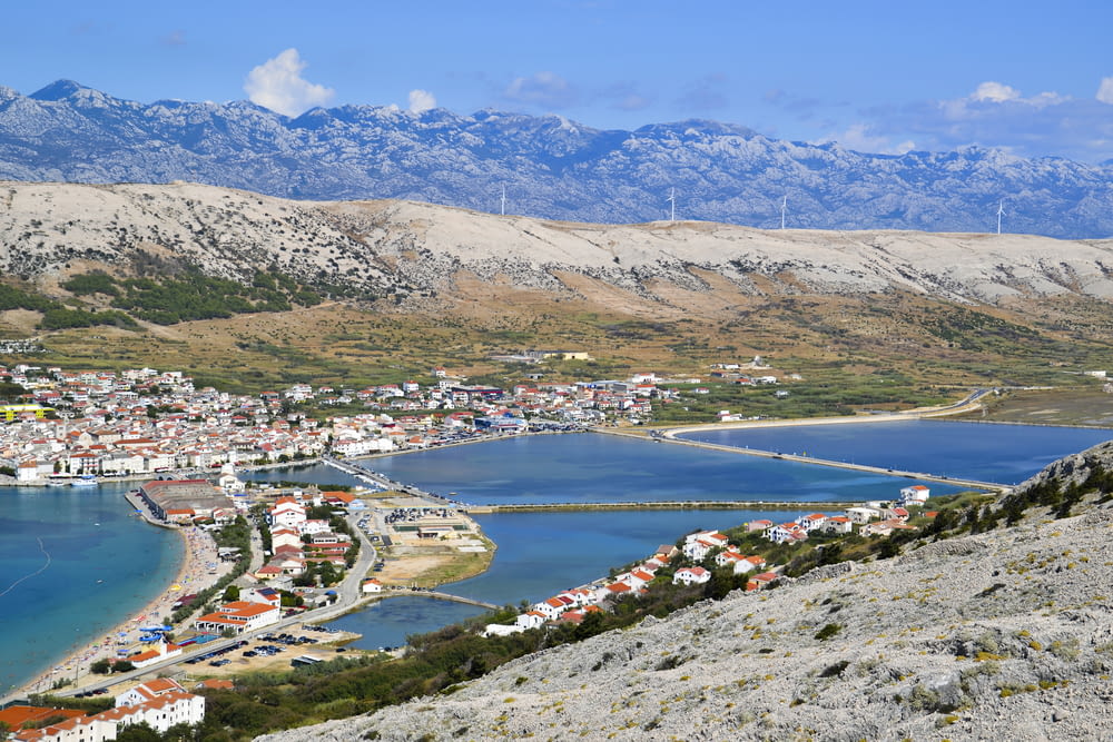 a view of a town and a body of water with mountains in the background