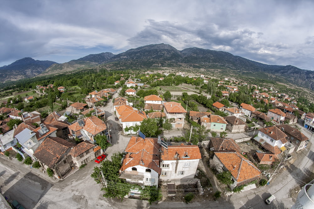 a bird's eye view of a village with mountains in the background