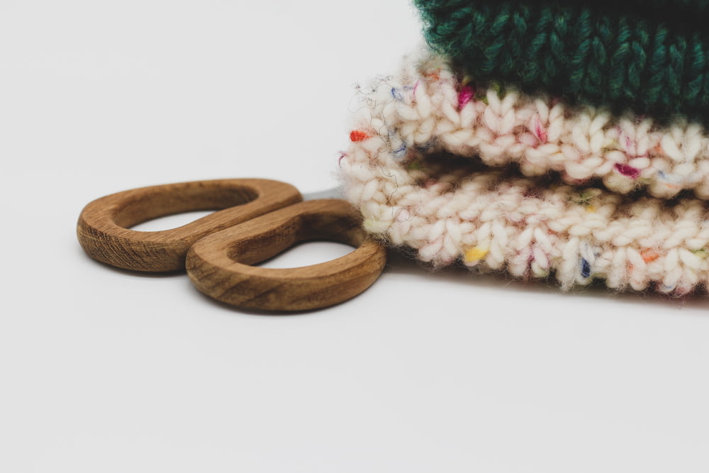 a pair of wooden rings sitting next to a pile of knitted blankets