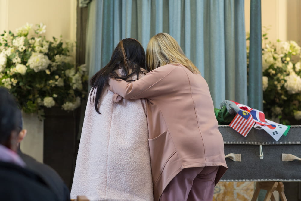 two women hugging each other at a ceremony