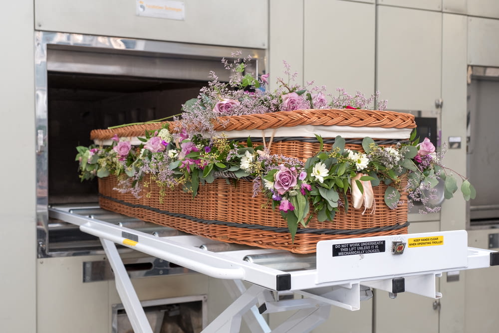 a wicker basket with flowers in it on a conveyor belt