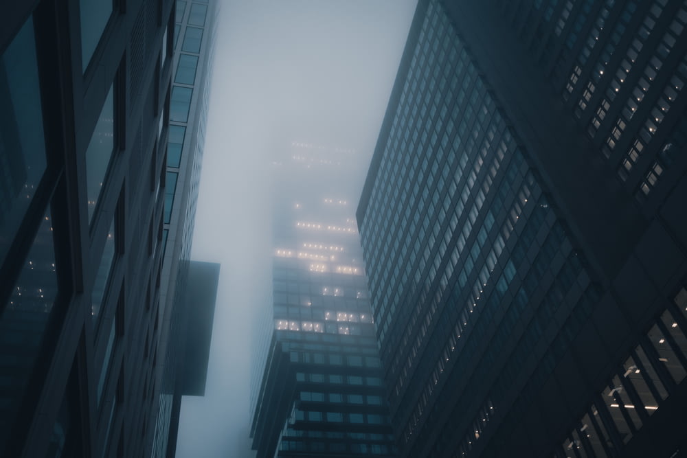 a foggy city street with tall buildings