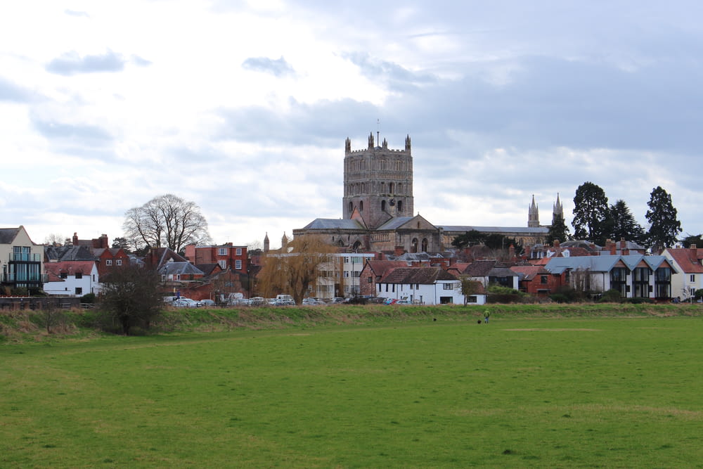 a grassy field with a church in the background