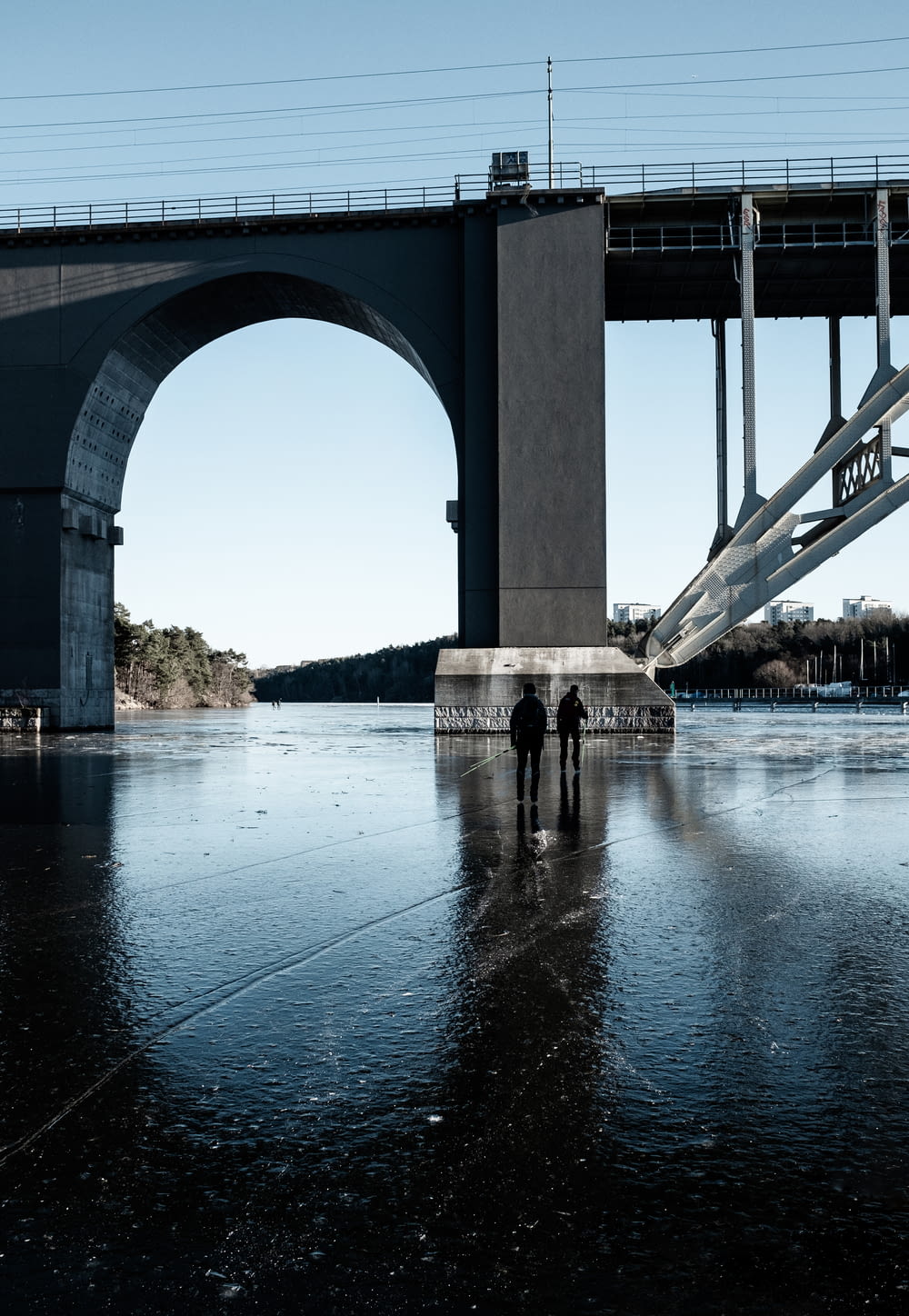 two people are standing in front of a bridge