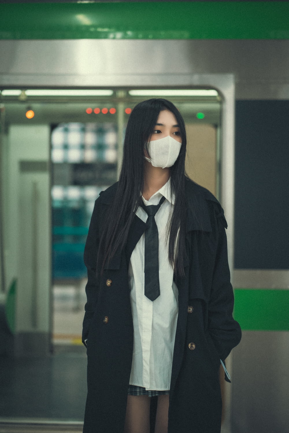 Una donna che indossa una maschera facciale in piedi in una stazione della metropolitana