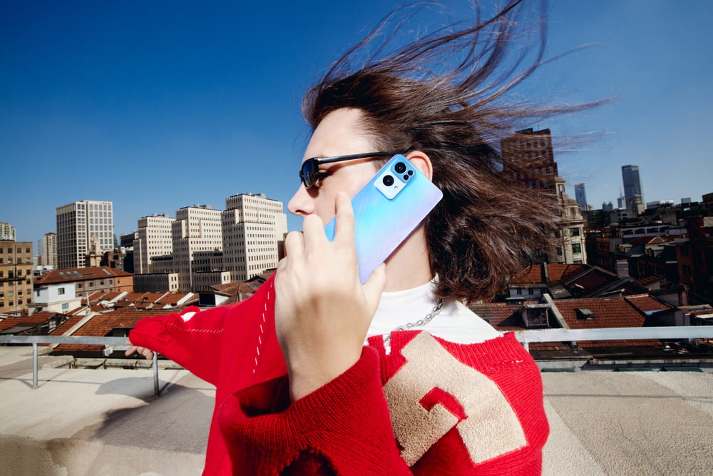a woman talking on a cell phone while holding a cell phone to her ear