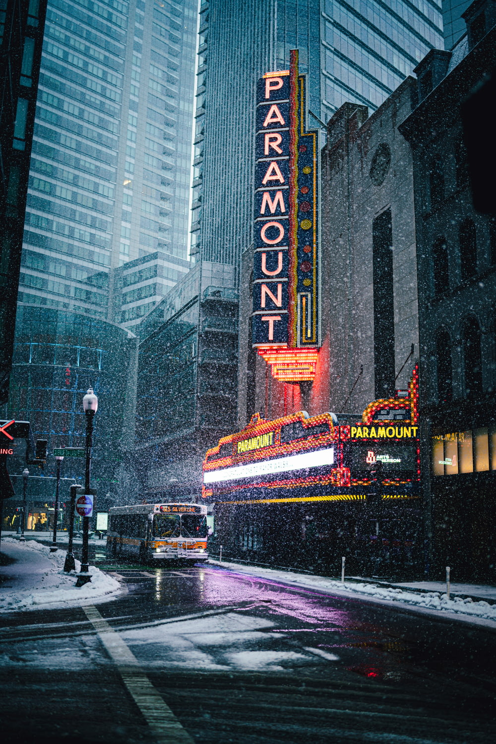 a city street in the snow with a marquee