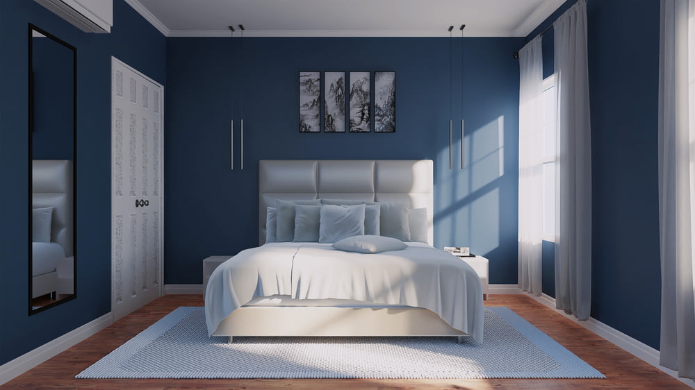 a bedroom with blue walls and a white bed