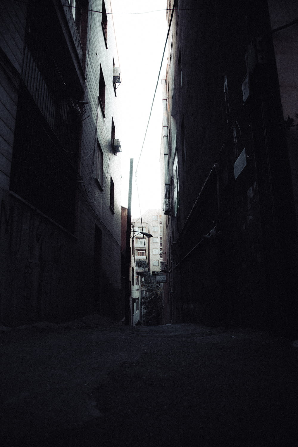 a dark alley way with a street sign on it