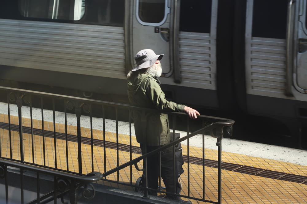 a man standing on a rail next to a train