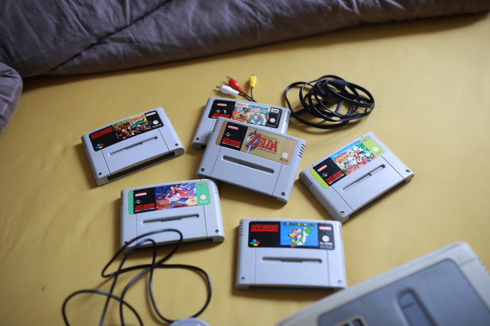 a bunch of nintendo games sitting on top of a bed