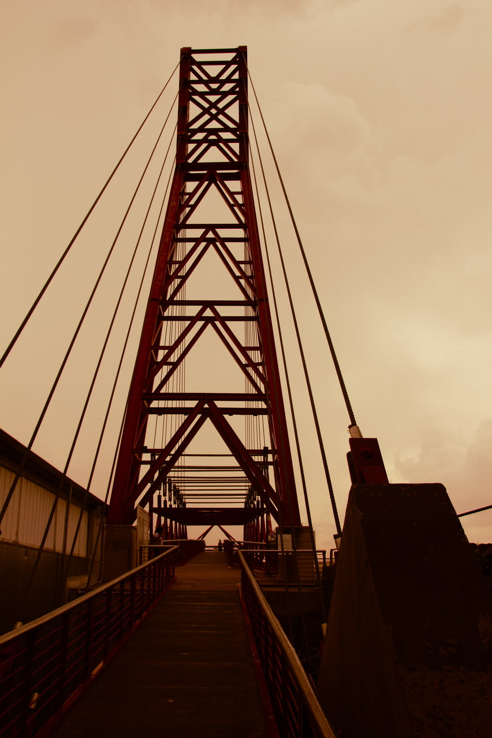 a tall red bridge with a sky in the background