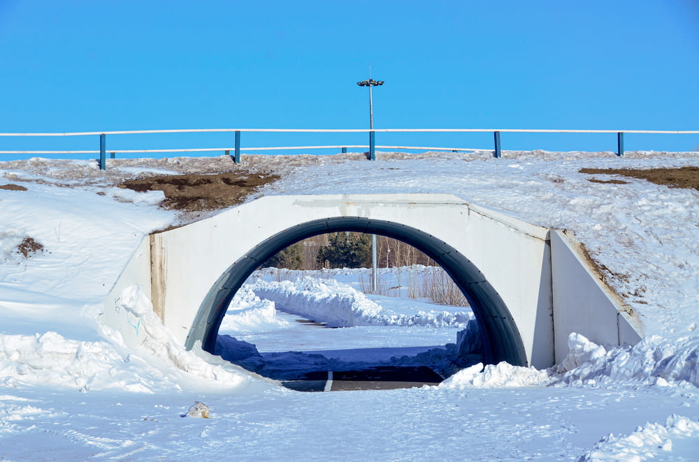 a snow covered road with a tunnel in the middle
