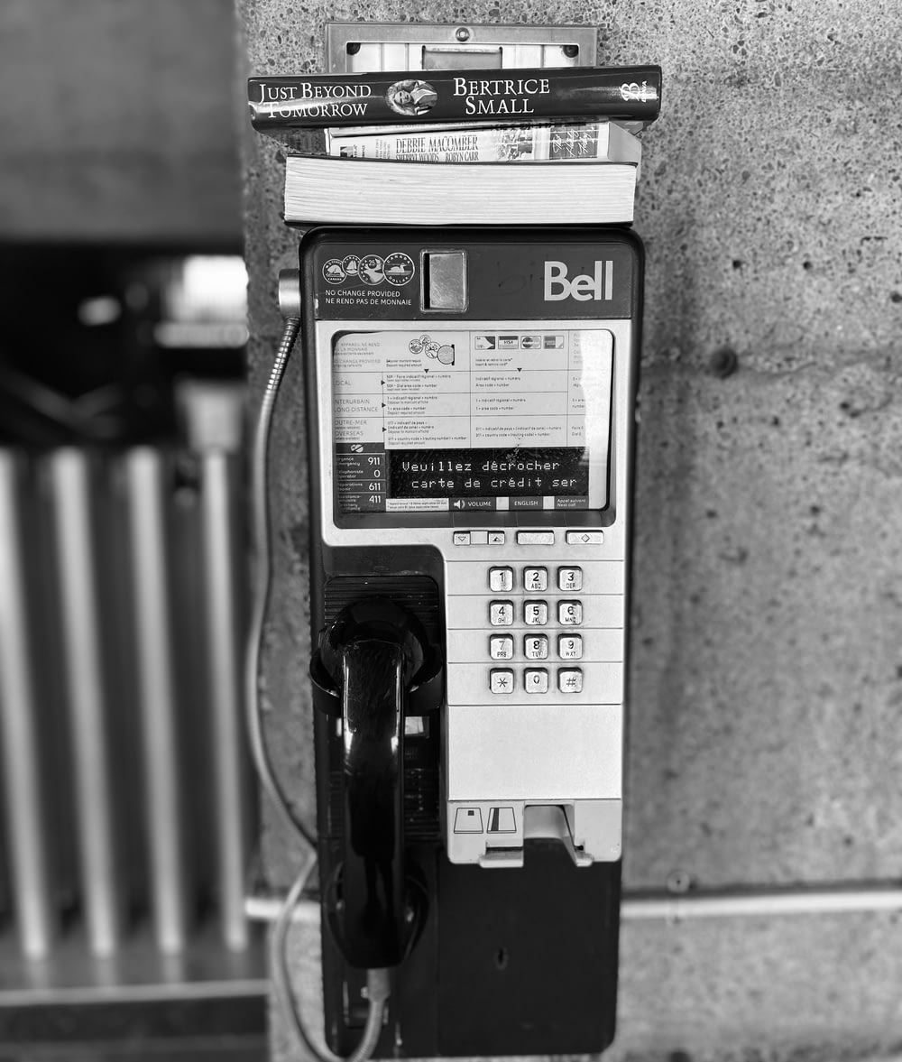 a black and white photo of a pay phone