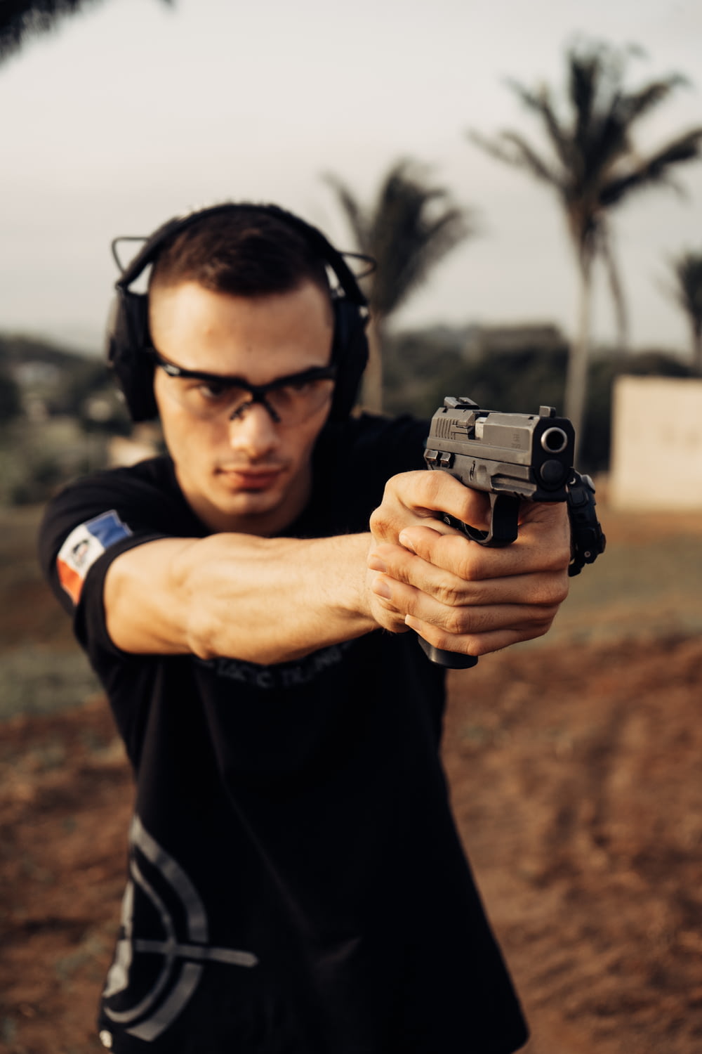 a man wearing headphones aiming a gun