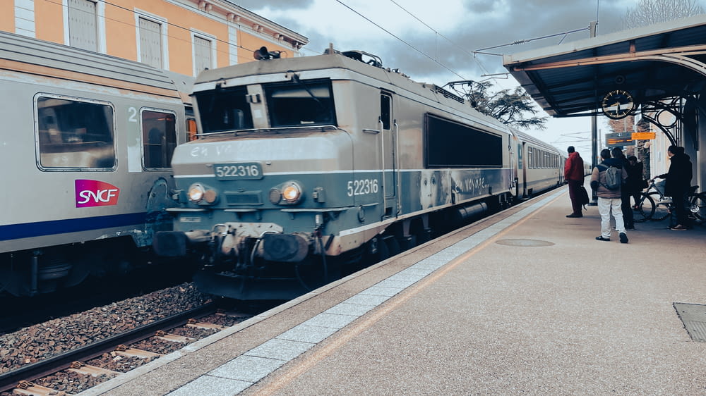 a silver train pulling into a train station