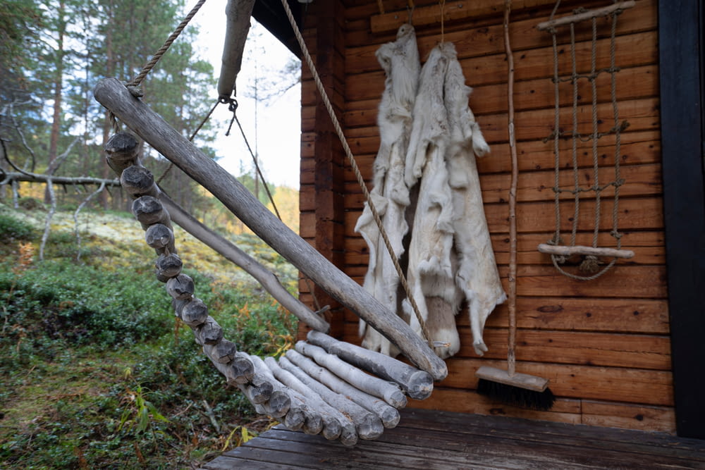 a wooden porch with a rope swing and a coat hanging on the wall