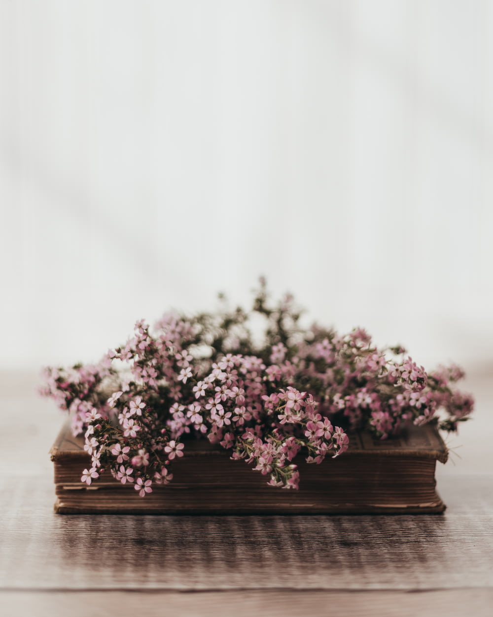 a wooden box filled with purple flowers on top of a table