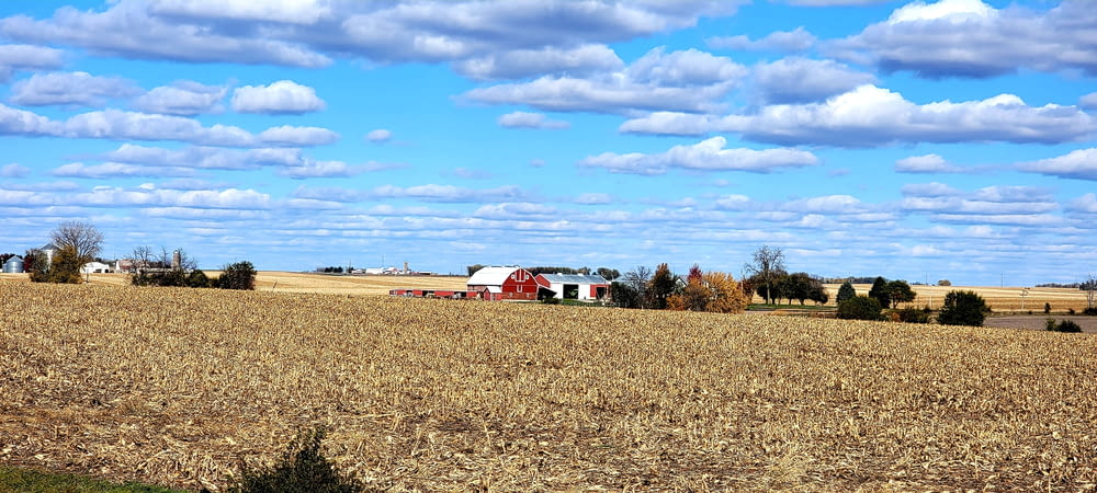 a farm with a red barn in the middle of a field
