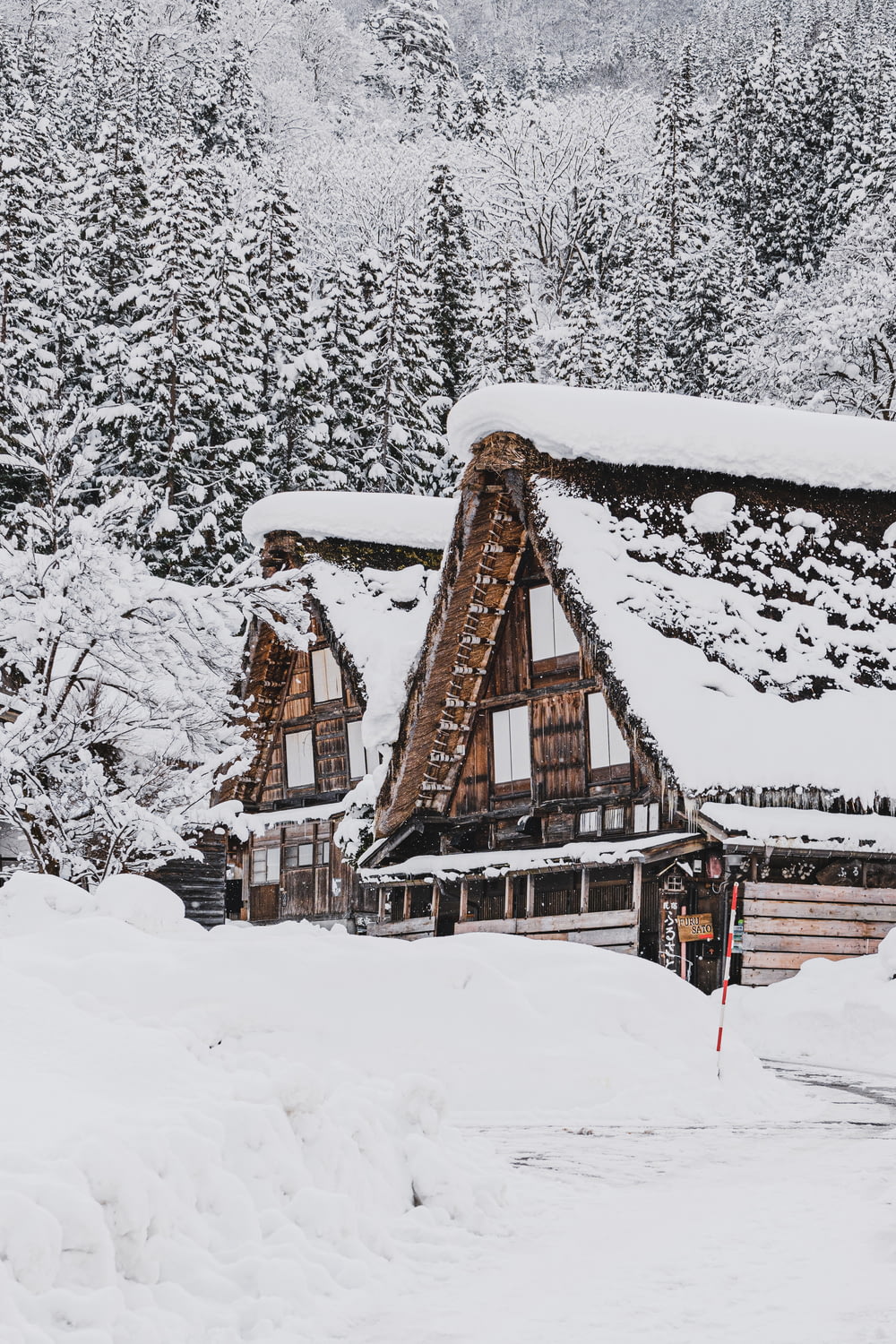 a ski lodge covered in snow with trees in the background