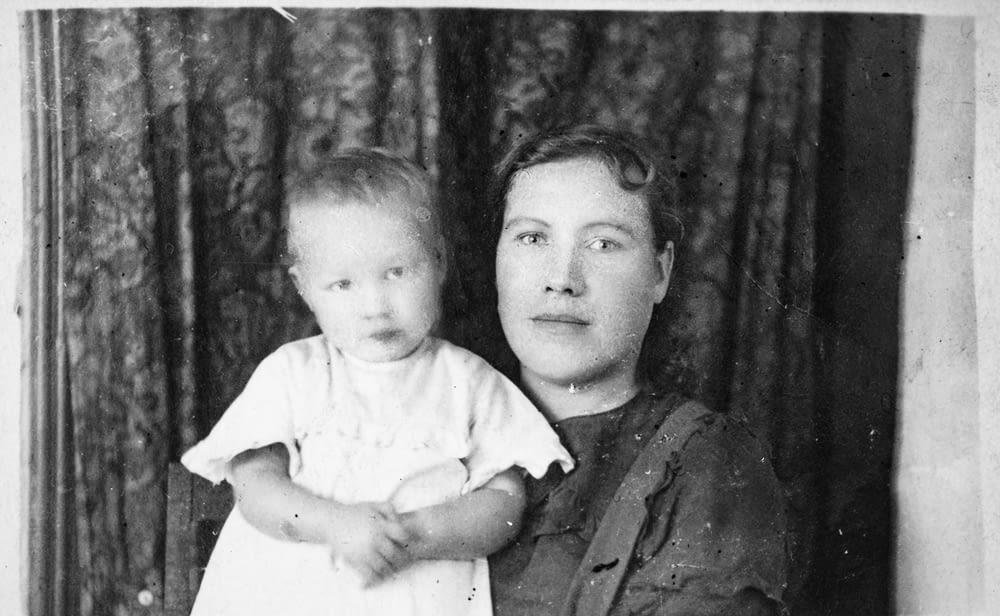 Una foto en blanco y negro de una mujer sosteniendo a un bebé