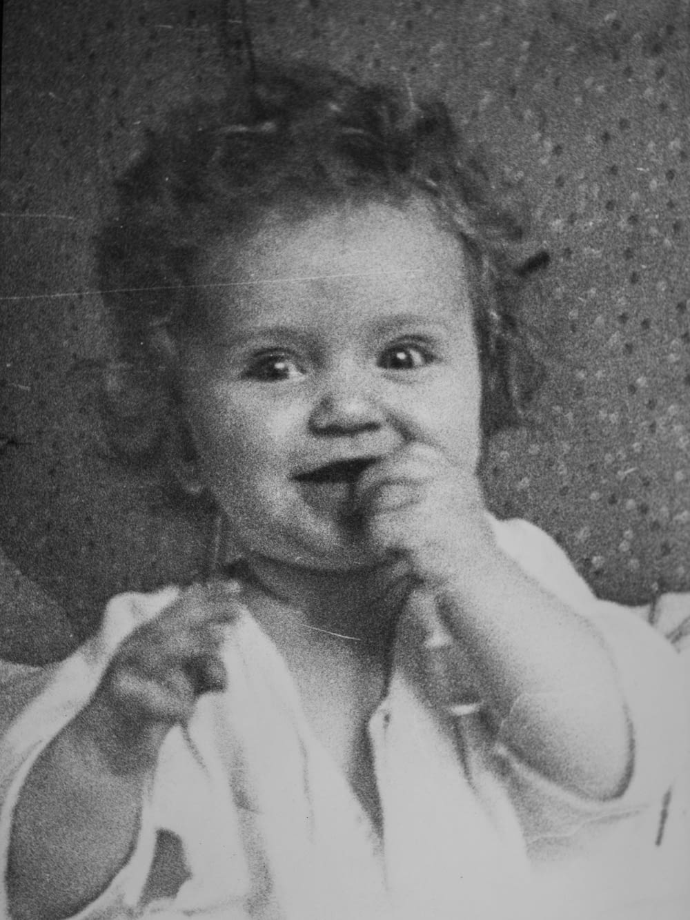 Una foto en blanco y negro de una niña comiendo algo