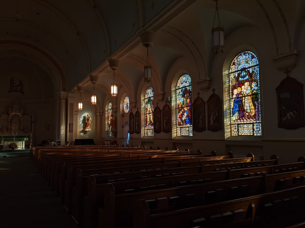 a church with stained glass windows and pews