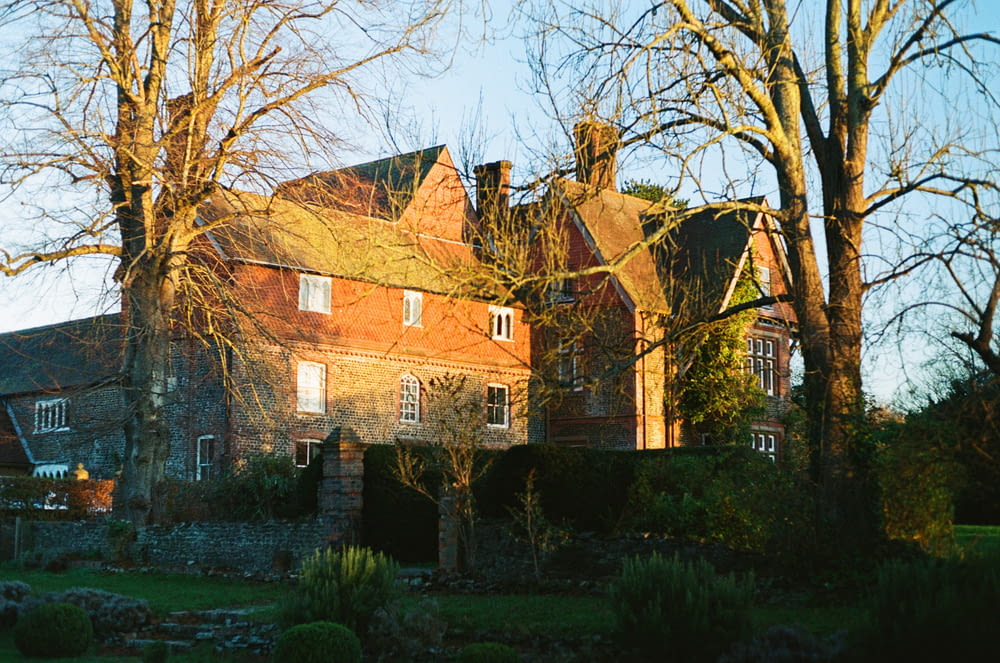 a large brick house surrounded by trees and bushes
