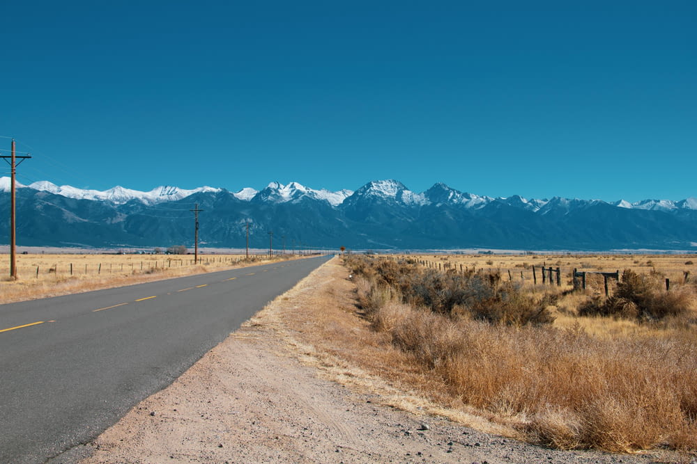 an empty road with mountains in the background