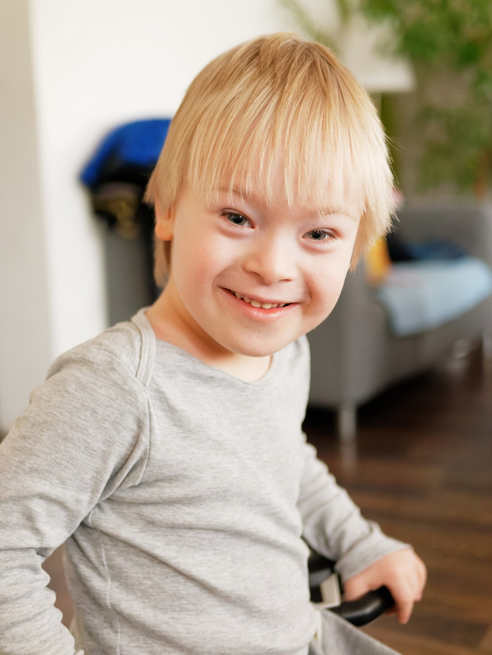 Ein kleiner Junge sitzt auf einem Stuhl mit einem Lächeln im Gesicht