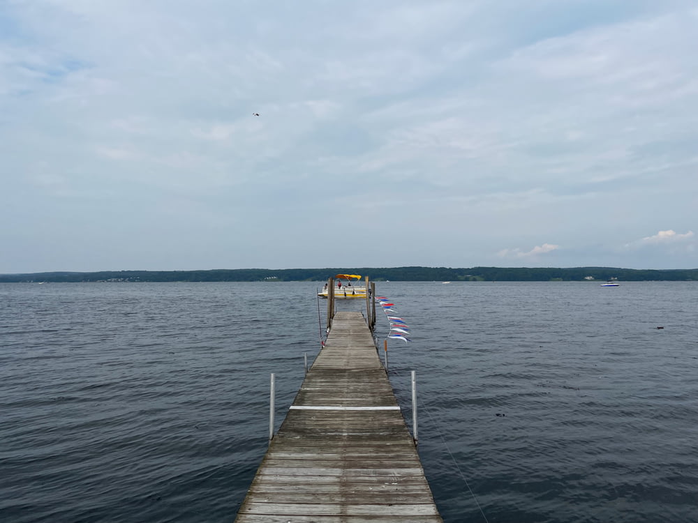 a dock on a lake with flags on it