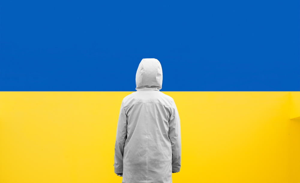 a person standing in front of a blue and yellow wall