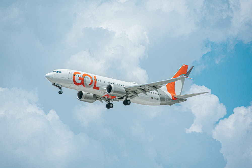 a white and orange airplane flying in the sky