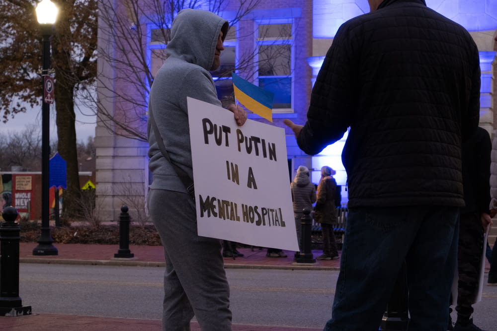 a man in a hooded jacket holding a sign