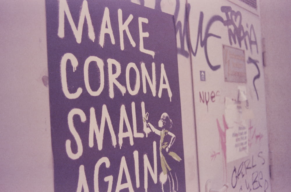 a purple sign that says make corona small again