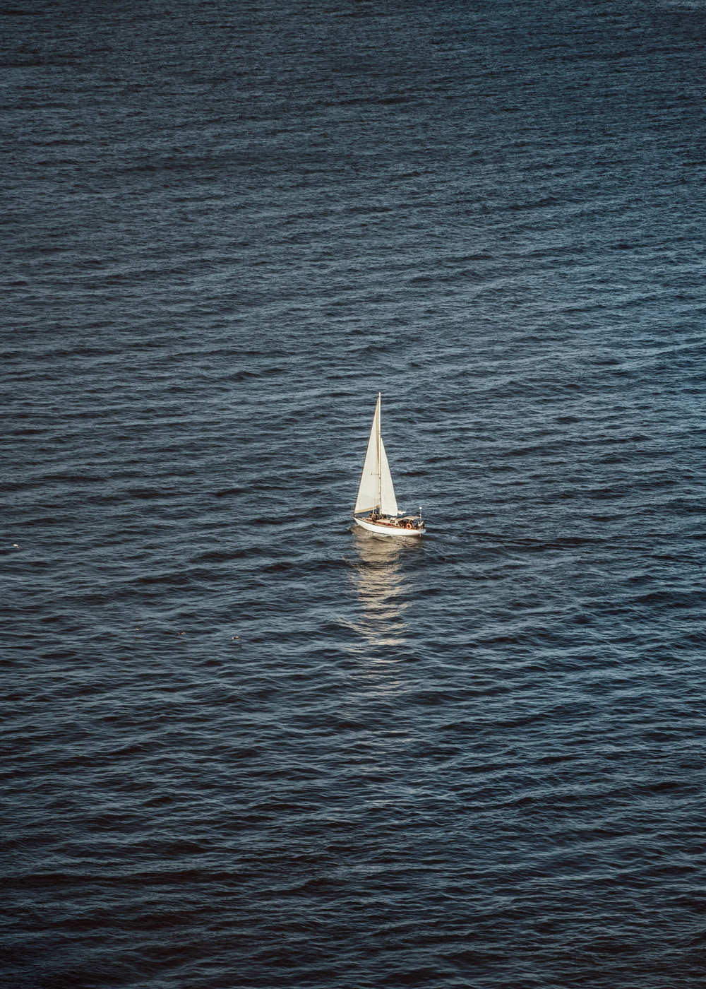 a small sailboat floating on top of a large body of water