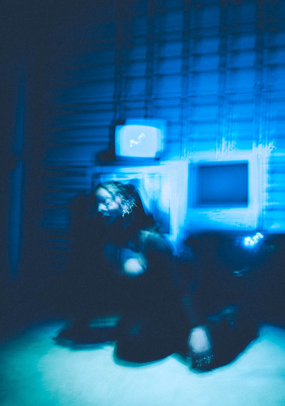 a blurry photo of a person sitting in front of a tv